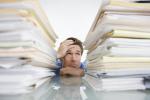 ManInMiddleOfPaperStacks.jpg
