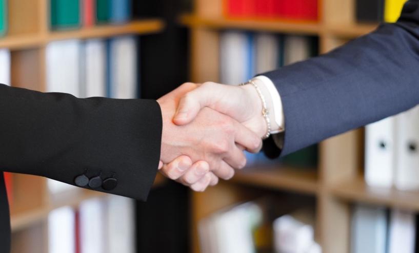 Private equity professional shaking hands on closing a deal